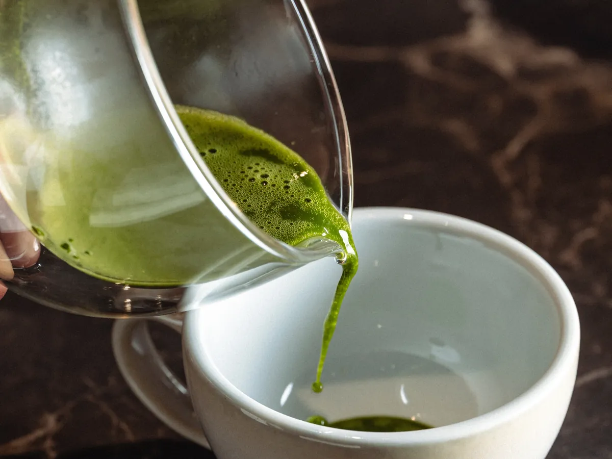 Matcha being poured into a white cup
